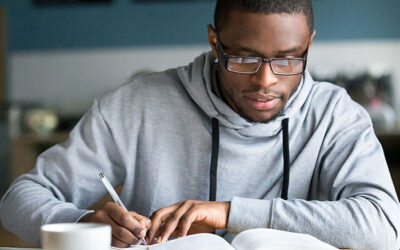 male_student_reading_book_and_writing Doctor of Divinity Degree